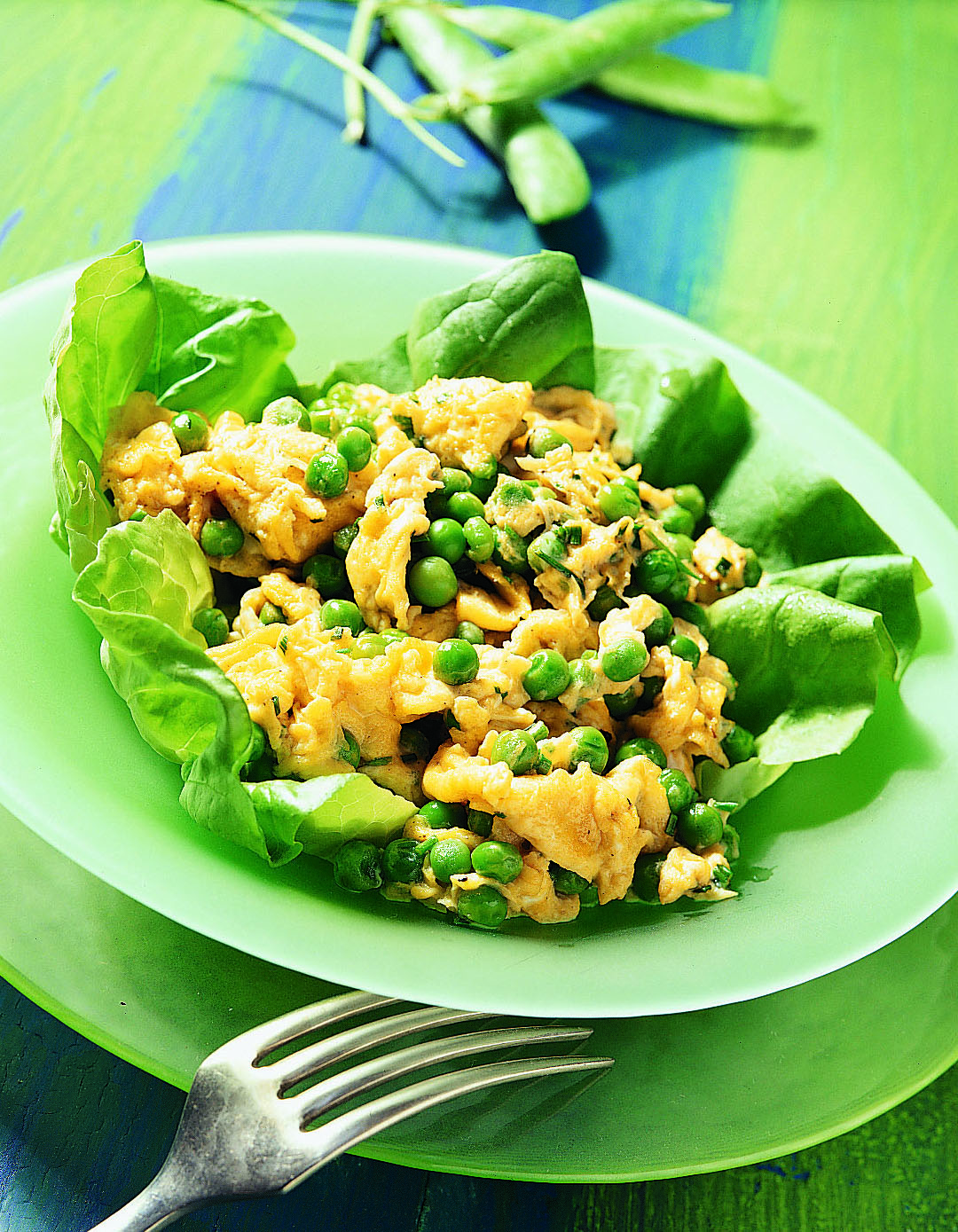Oeufs brouillés aux petits pois sur lit de salade