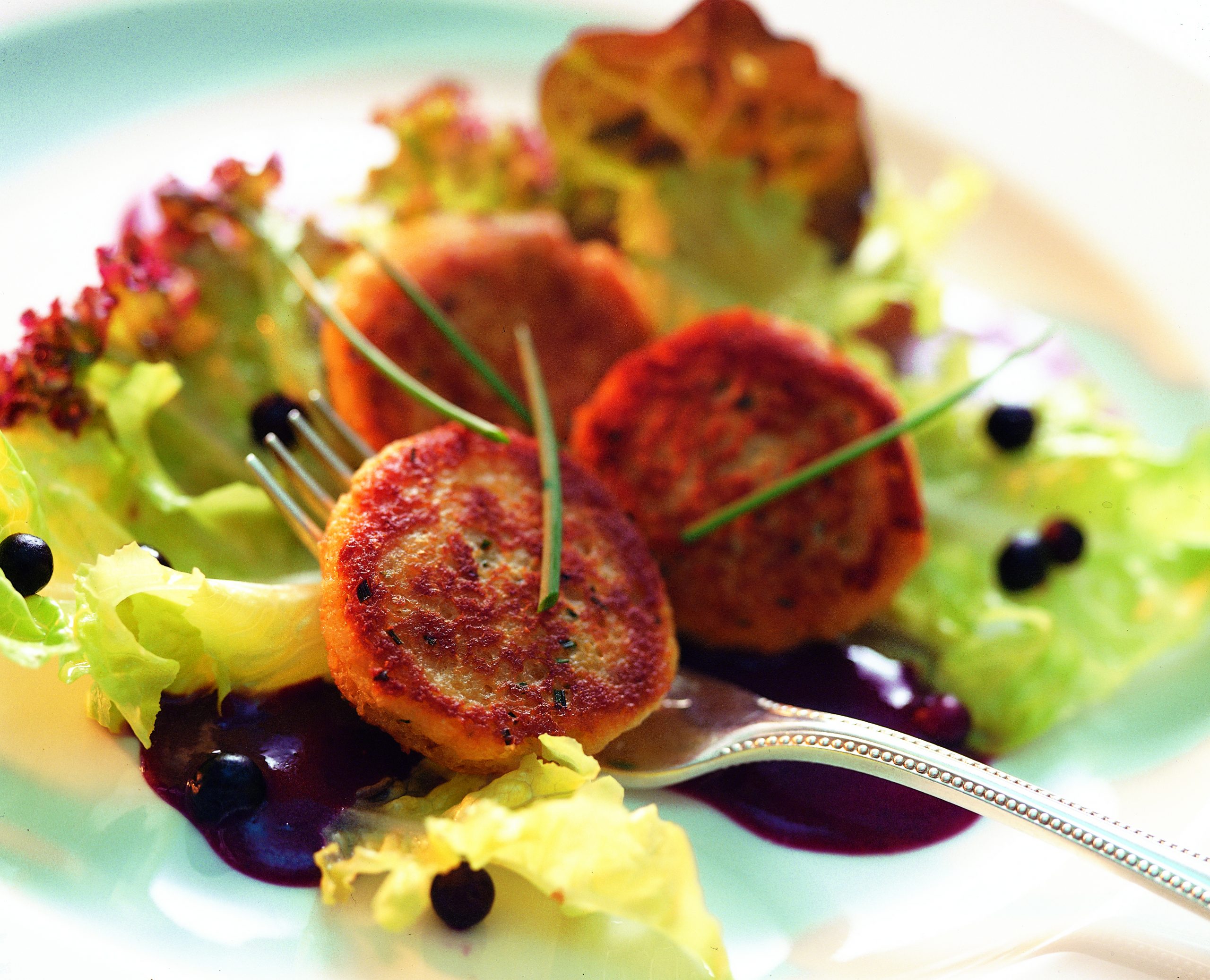 Galettes au fromage de brebis frais sur un canapé de salade estivale