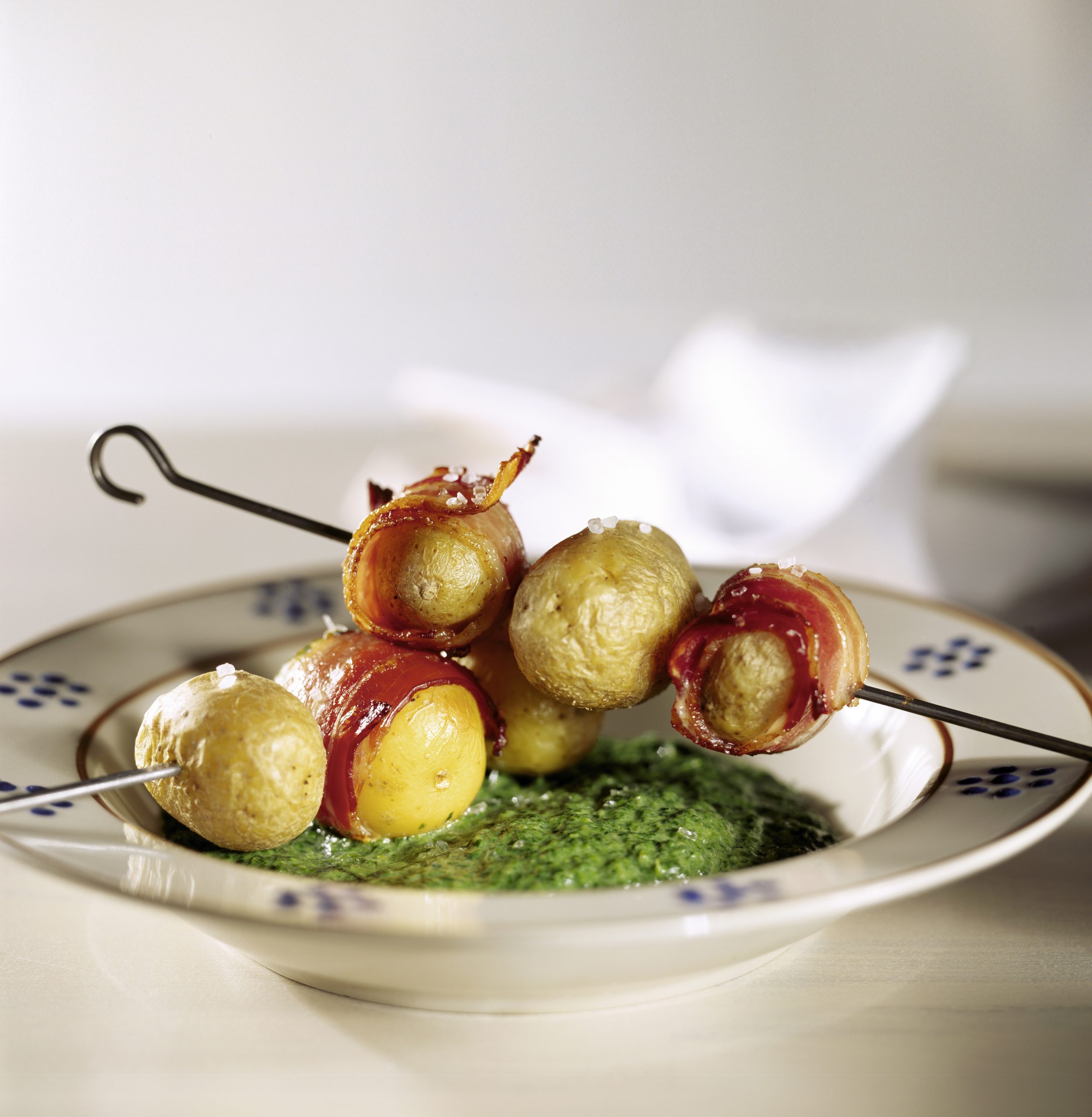 Brochettes de pommes de terre au lard sur lit d'épinards