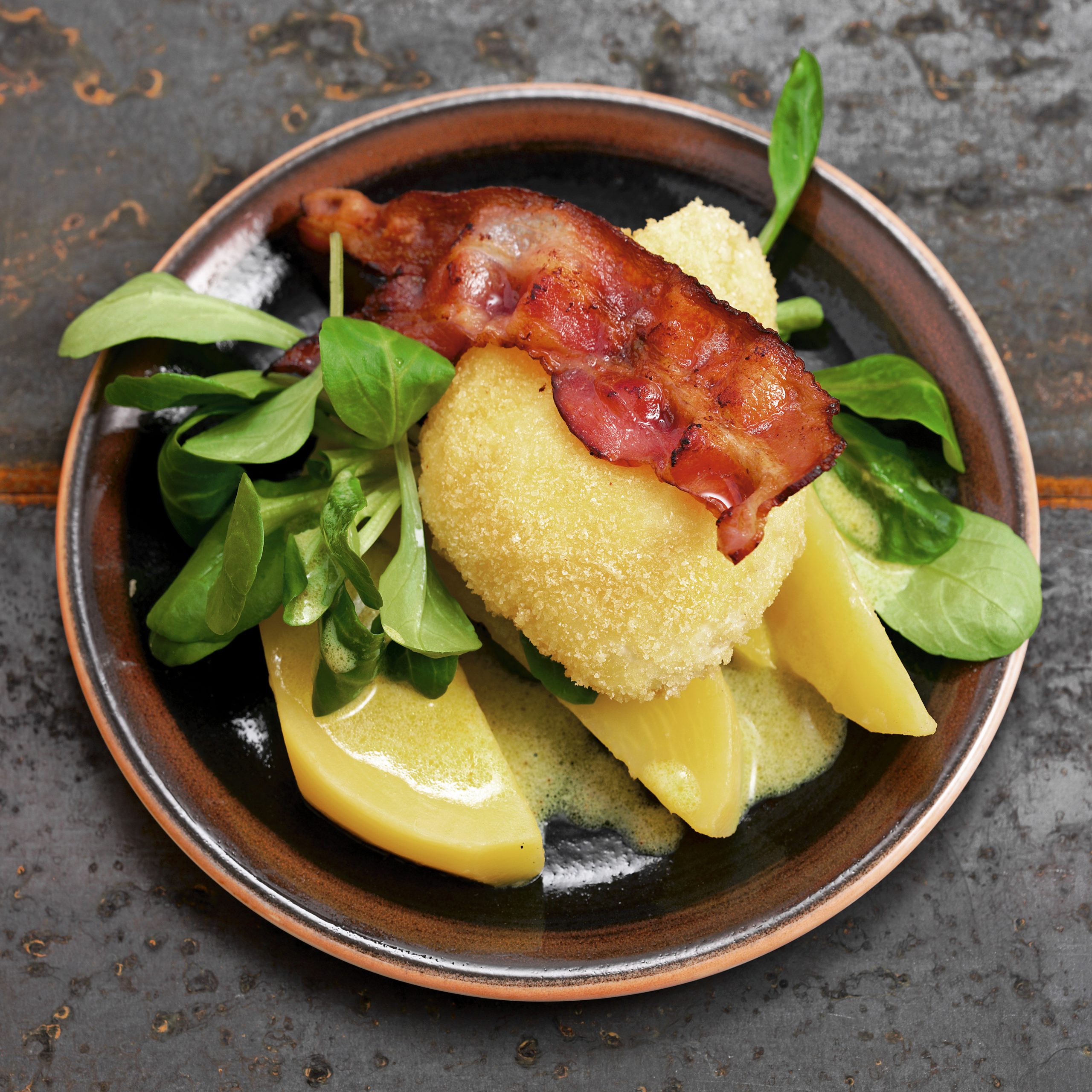 Oeufs panés sur lit de salade
