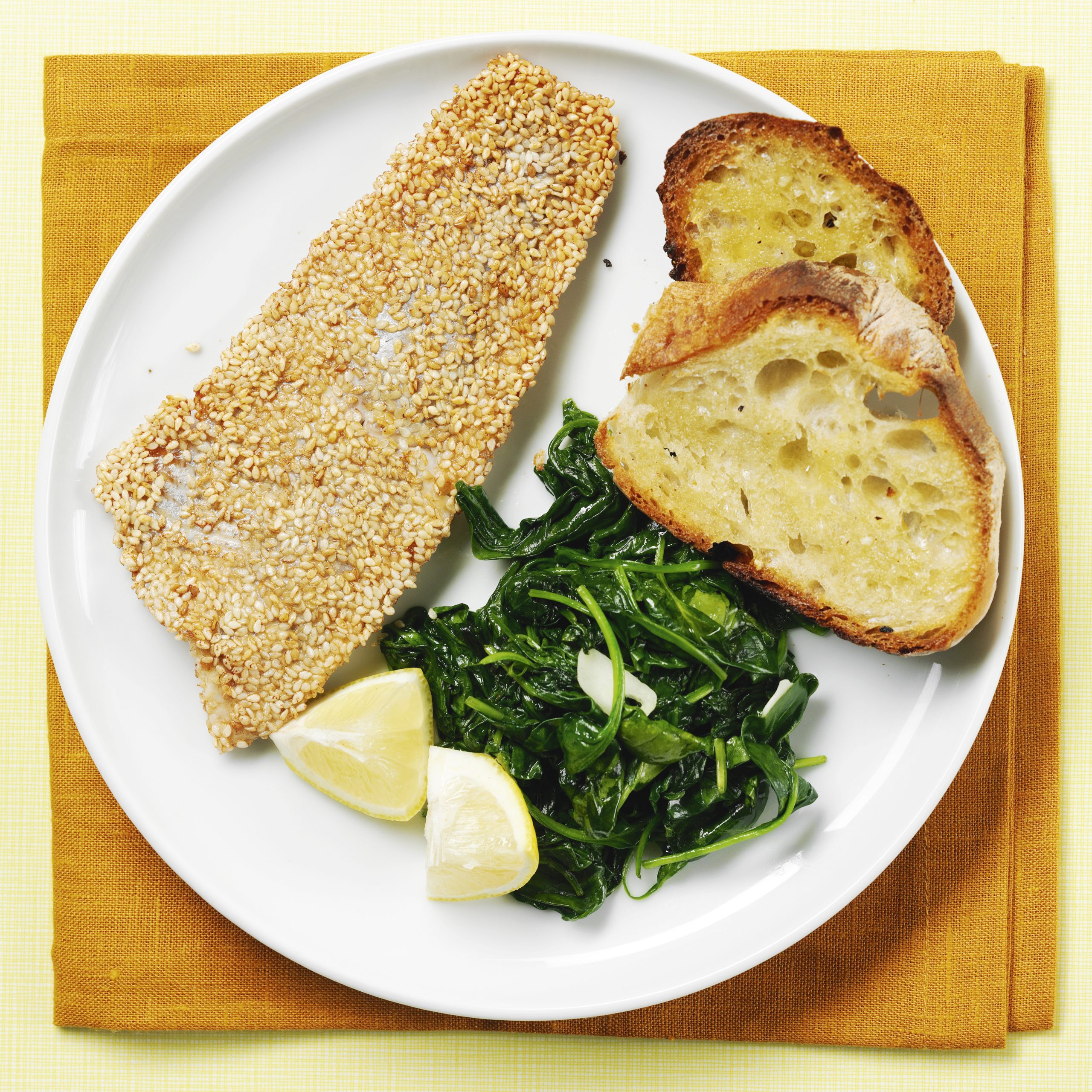 Sesam-Fisch mit Spinat und Knoblauchbrot